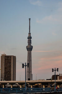 Modern buildings in city against sky during sunset