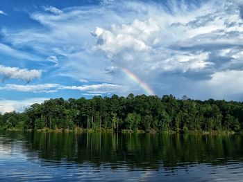 Scenic view of okhissa lake by trees against cloudy sky