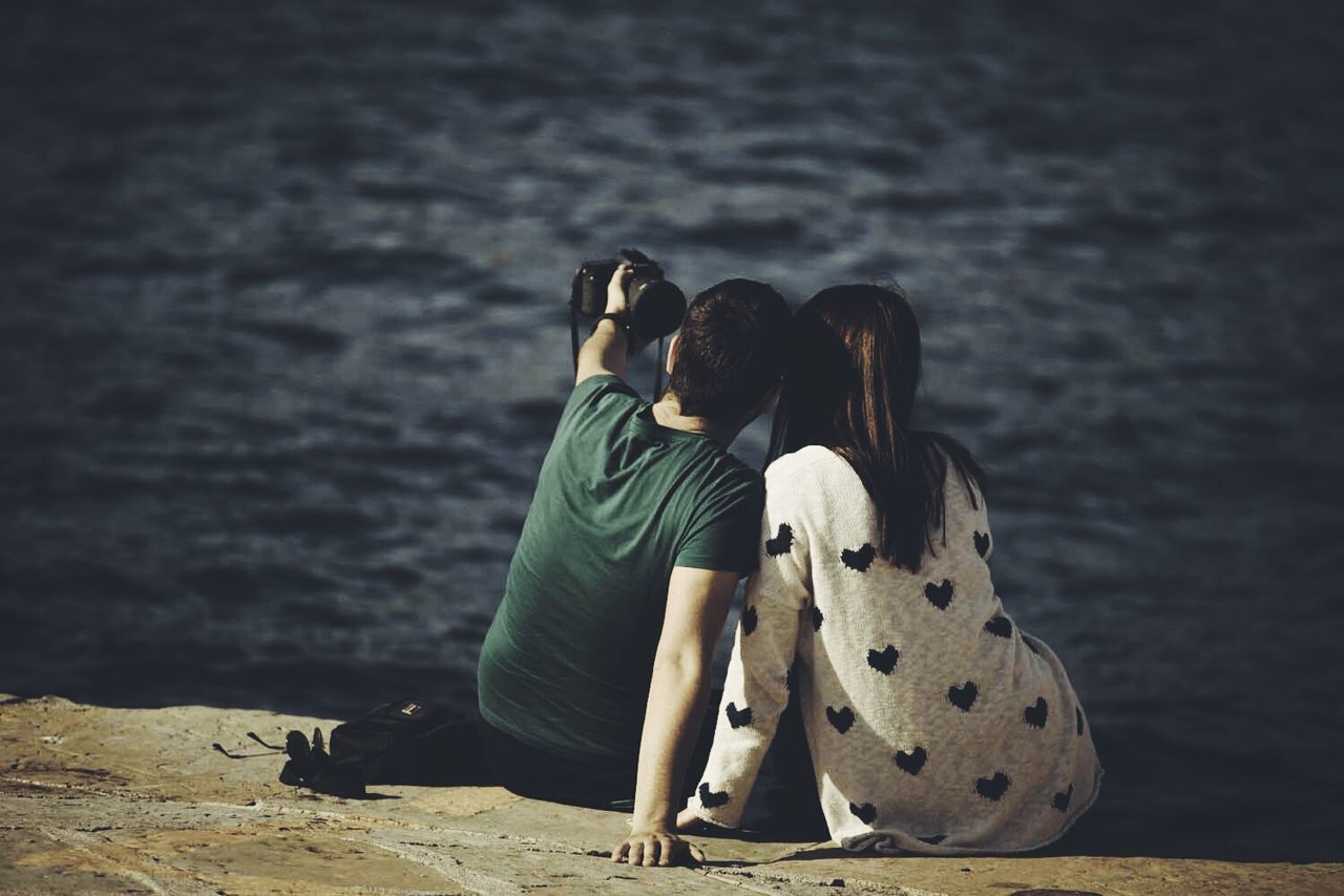 water, lifestyles, leisure activity, rear view, full length, casual clothing, sea, focus on foreground, beach, three quarter length, standing, shore, lake, sitting, vacations, nature, outdoors, relaxation