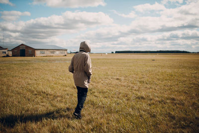 Rear view of man walking on field