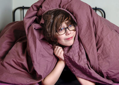 Portrait of young woman sitting on sofa at home