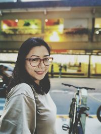 Portrait of smiling young woman with bicycle