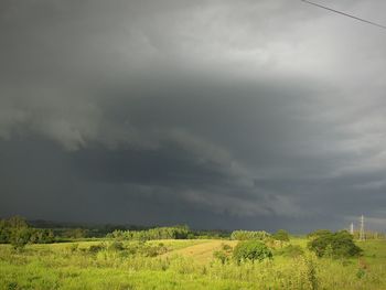 Scenic view of field against dramatic sky