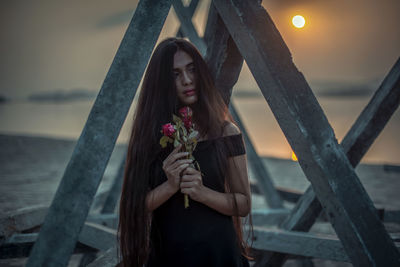 Woman standing by pink flower