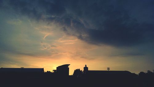 Silhouette of building against cloudy sky