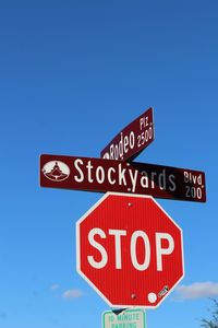 Low angle view of road signs against blue sky
