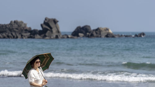 Woman on beach against sky