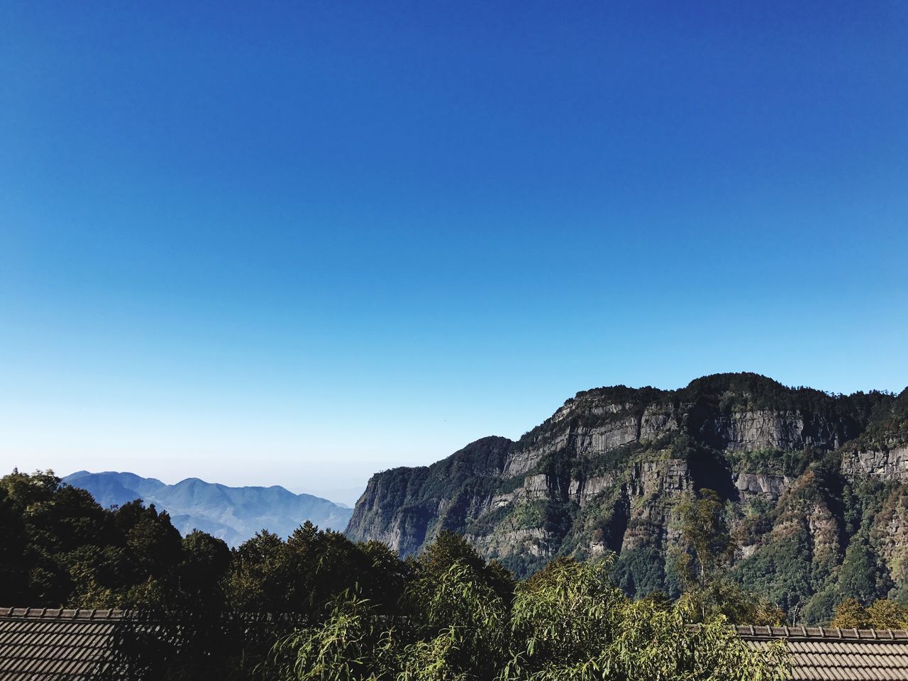 blue, copy space, clear sky, beauty in nature, mountain, nature, tranquil scene, scenics, tranquility, no people, day, tree, outdoors, mountain range, landscape, travel destinations, sky