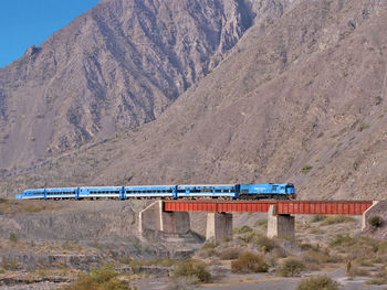 Train on bridge by mountain