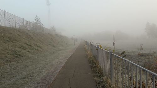 Panoramic view of footpath against sky during winter