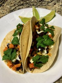 Vegetarian taco with a savory sweet potato black bean filling served on a warm tortilla 