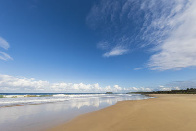 Scenic view of beach against blue sky