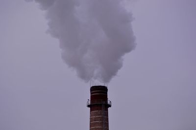 Low angle view of smoke stack against sky