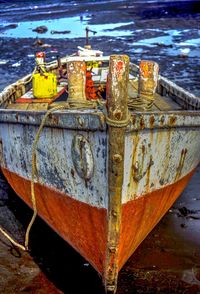 Close-up of boat moored at harbor against sky