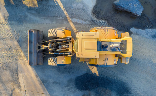 Dirrectly above shot of yellow earthmover on road