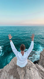 Rear view of man in sea against sky