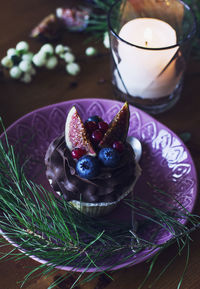 Chocolate cupcake with figs and berries on a wooden from top
