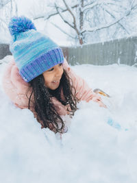 Portrait of smiling young woman standing on snow