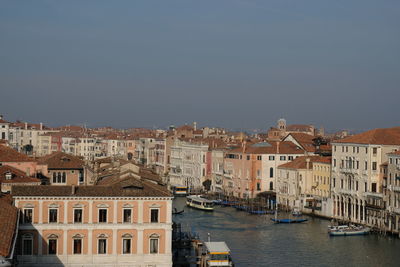 Canal amidst buildings in town against clear sky