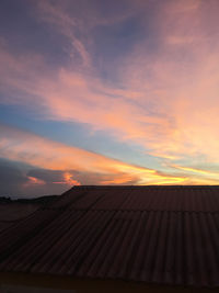 Roof of house against sky during sunset