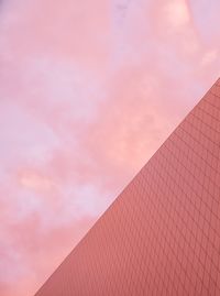 Low angle view of pink building against sky