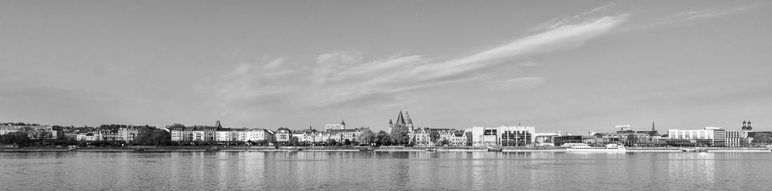 River by cityscape against sky