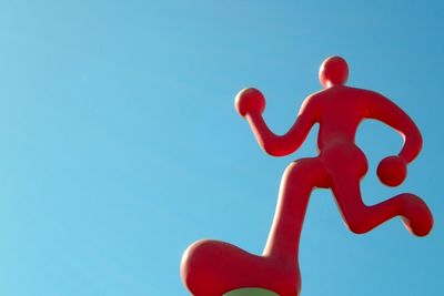 Low angle view of red sign against clear blue sky