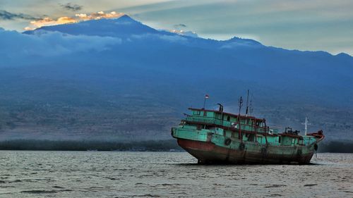 Fishing boat in sea against sky