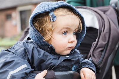 Close-up of cute baby girl wearing warm clothing looking away