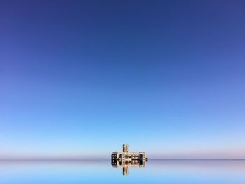 Mid distance of torpedownia on sea against clear blue sky