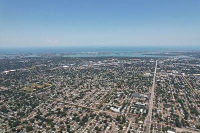 High angle view of city by sea against clear sky