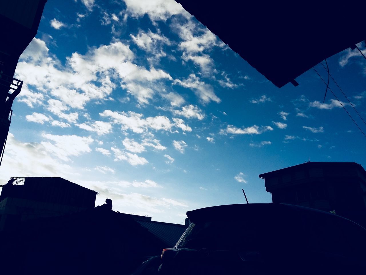 LOW ANGLE VIEW OF BUILDINGS AGAINST BLUE SKY