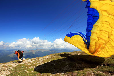 One person preparing to take off with paraglider