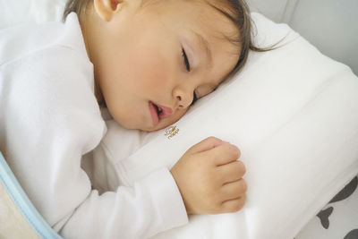 High angle view of baby sleeping in bed