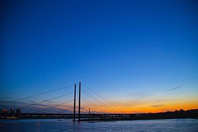 Bridge over river against sky during sunset