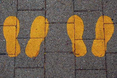 High angle view of yellow arrow sign on street