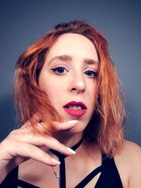 Portrait of beautiful woman against gray background