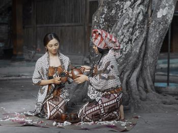 Woman wearing traditional clothing drinking tea outdoors