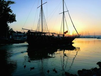 Sailboats in sea at sunset