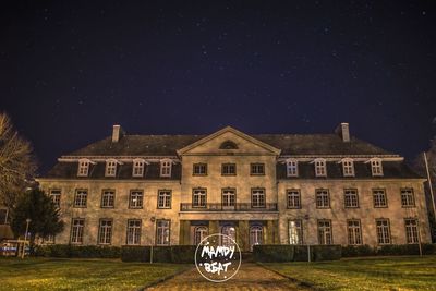 Facade of illuminated house against sky at night