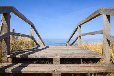 Wooden structure on beach against sky