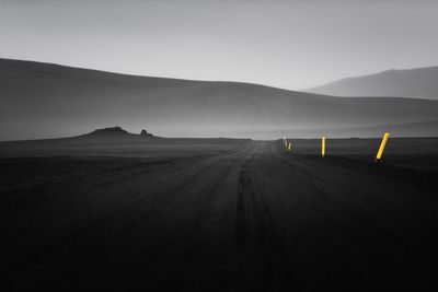 Road by mountains against sky
