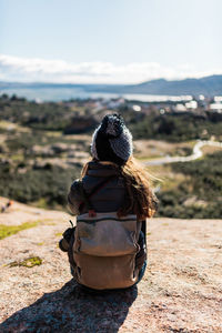 Rear view of woman looking at camera on sunny day