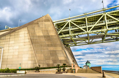 Low angle view of bridge against cloudy sky