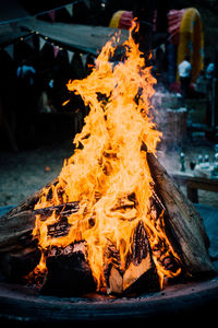 Firewood burning in fire pit at campfire