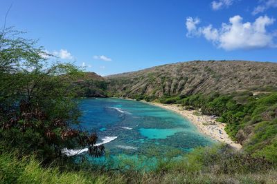 Scenic view of sea and mountains against blue sky