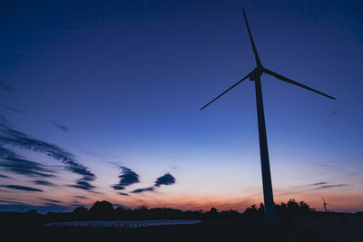 Silhouette windmill against sky at sunset