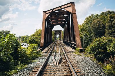 View of railway bridge amidst trees against sky