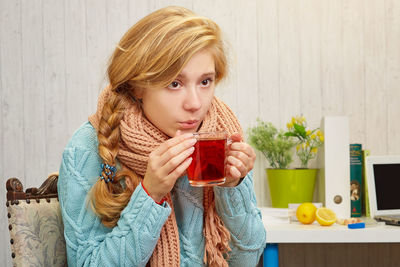 Portrait of woman holding ice cream on table