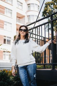 Portrait of young woman wearing sunglasses standing outdoors